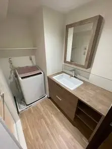 ナチュラルな優しい色合いの洗面脱衣所へ