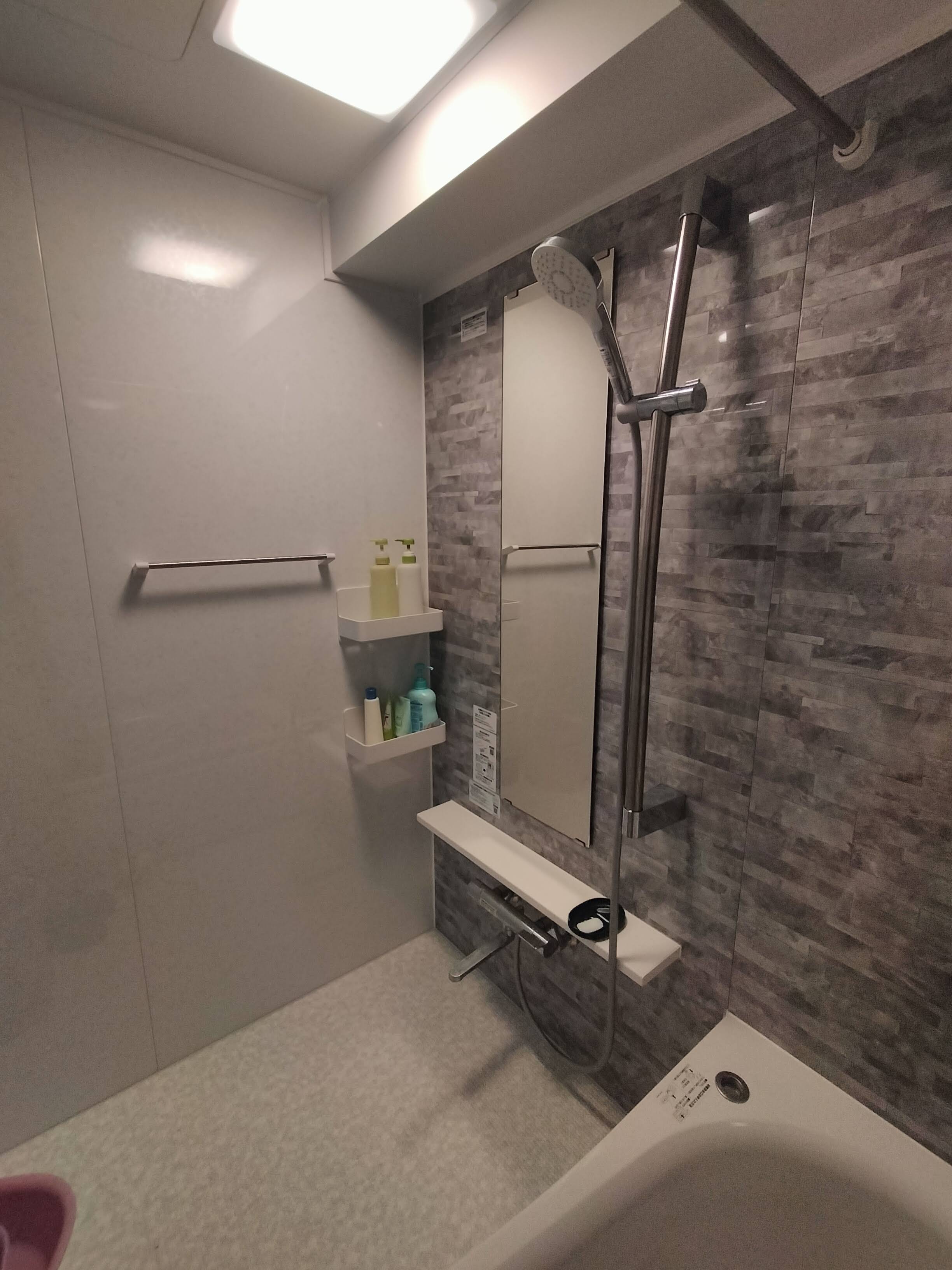 タオル掛け、マグネット式の棚、鏡、カウンター、混合水栓。手摺兼用スライドバー、シャワー