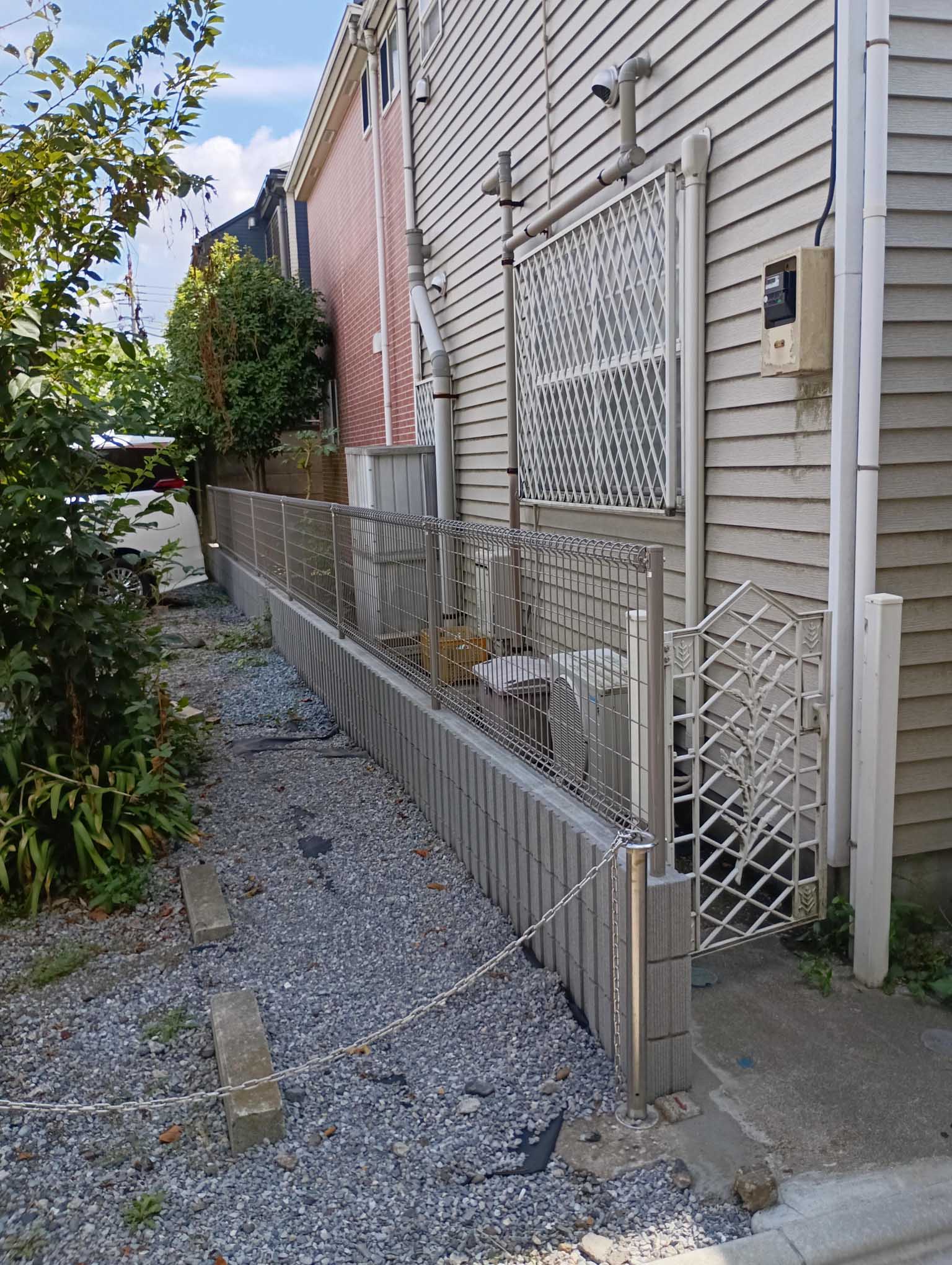 施工後の塀を駐車場側から見ています。建物と扉は、今回の塀の交換工事の対象ではありません。